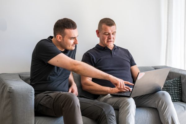 zwei software berater in einem gespräch über einem laptop